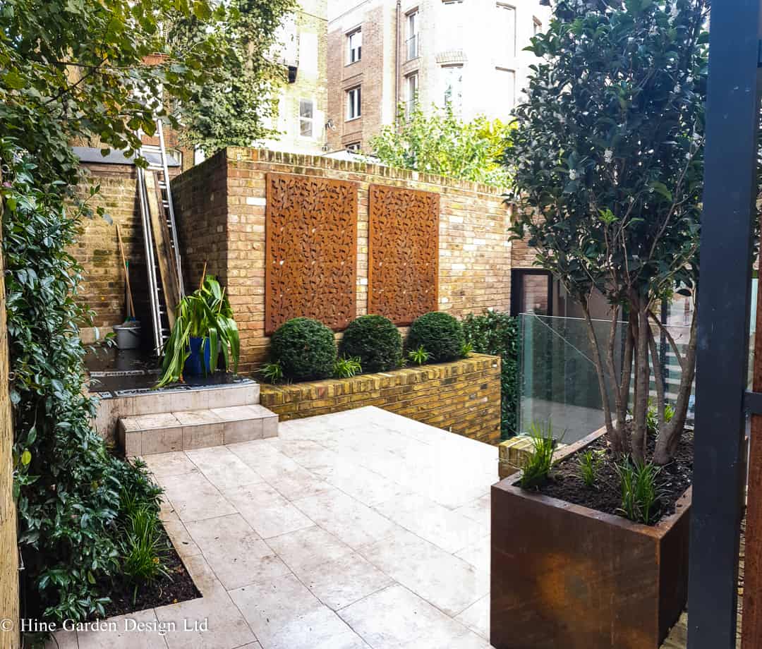 small Hampstead courtyard garden with mature planting and Corten elements