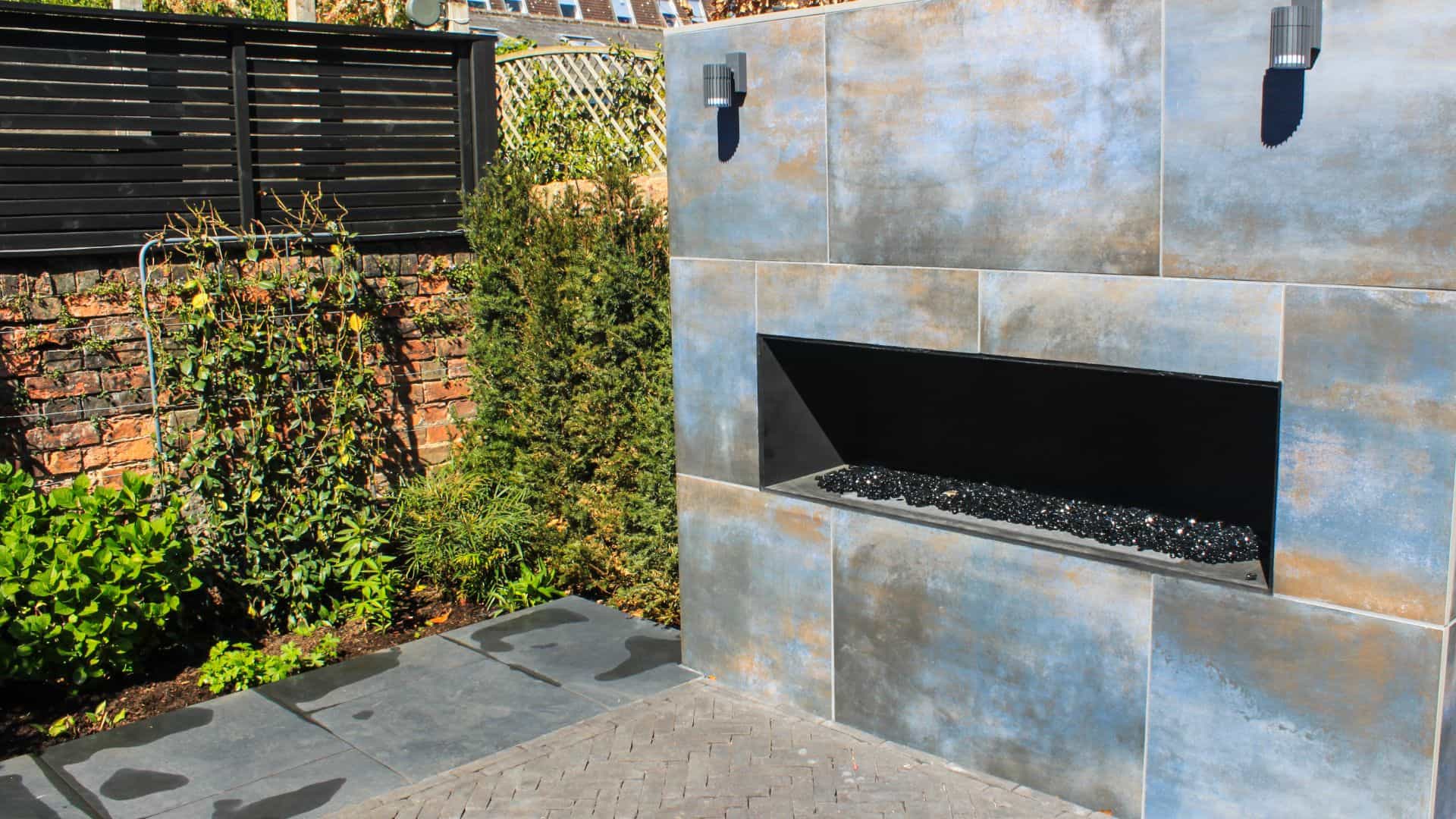 topiary in a london courtyard garden design with corten panels on brick walls with stairs for a level change and glass handrail