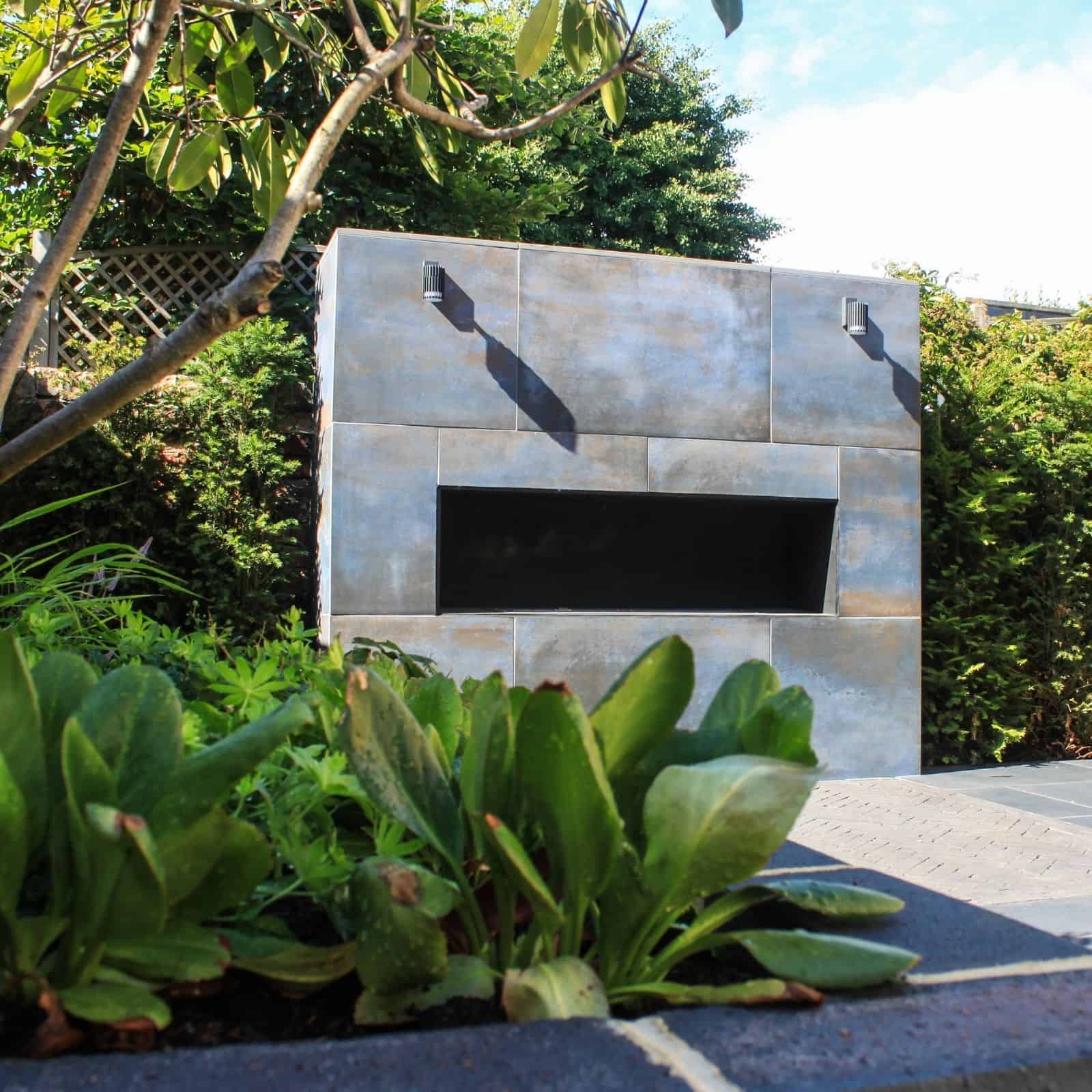 designed steps in garden wall with planting and corner pergola in white surrounding a garden area for entertaining with dining table