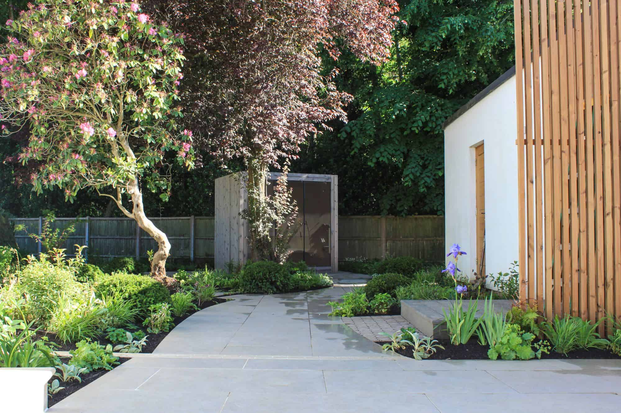 designed steps in garden wall with planting and corner pergola